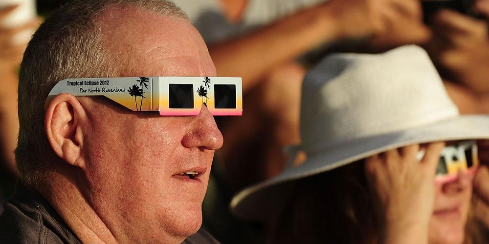 Mensen kijken met behulp van speciale 'eclipsbrilletjes' naar een zonsverduistering